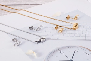 Detail of gold and silver stainless steel jewelry set with abstract eye pendants