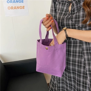 Detail view of light purple canvas lunch bag with gold magnetic buckle and handles