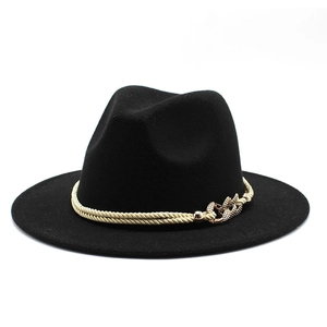 Détail d'un chapeau fedora noir avec ruban tressé doré et boucle ornée de strass