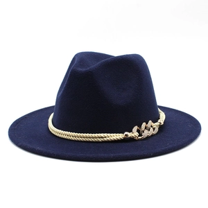 Détail d'un chapeau fedora en laine bleu marine avec cordes dorées et boucle de chaîne gravée