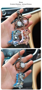 Detail of iridescent acrylic dinosaur keychain with glitter ball and metal clip