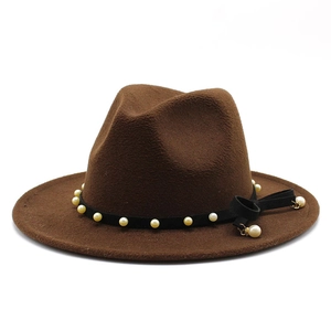Detail of wool fedora hat featuring velvet band with faux pearls and fringe tassel