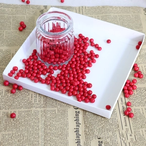 Artificial red berries in textured glass jar on vintage paper backdrop for home decor