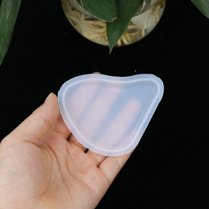 Handheld view of translucent silicone resin mold in teardrop and heart shapes for DIY jewelry