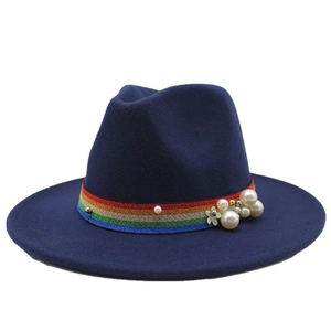 Navy blue wool fedora hat with rainbow ribbon and pearl flower trim on a white background