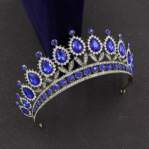 Detailed macro view of baroque crown featuring teardrop blue gems and vintage bronze alloy