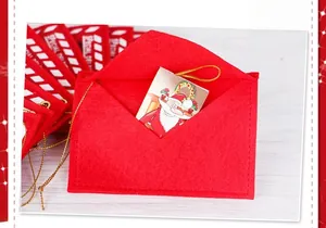 Detail of red felt Christmas envelope ornament with golden string and gift card