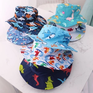 Close-up of children's cotton sun hats with colorful shark and dinosaur prints and chin straps