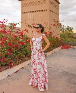 Outdoor shot of a white and red floral maxi dress with slim straps and an A-line silhouette