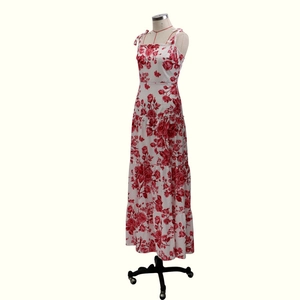 Detail of red rose floral print on white tiered summer sundress with spaghetti straps