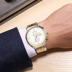 Detail of two-tone steel business watch worn with a navy suit and white shirt sleeve