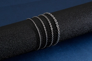 Detail showing four different thicknesses of stainless steel O-chains on black cylinders