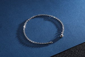 Detail of silver stainless steel O-chain bracelet with lobster clasp on blue background