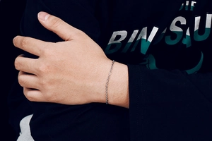 Close-up of minimalist silver stainless steel chain bracelet on wrist with lobster clasp