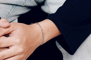 Detailed view of silver stainless steel cable chain bracelet on a person's wrist