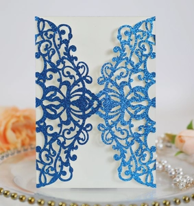 Close-up of royal blue glitter laser cut wedding invitation with intricate floral patterns