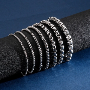 Multiple sizes of polished stainless steel box chains on a dark display stand