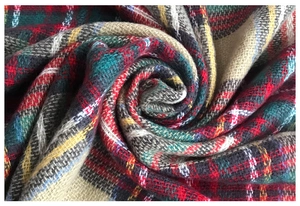 Close-up of vibrant cashmere-like fabric showing detailed plaid weave and soft texture