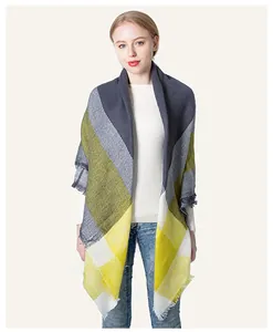 Detail of yellow and grey plaid cashmere-like scarf with soft decorative fringe edges