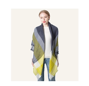 Close-up of yellow and grey plaid scarf with fringe details worn by a female model