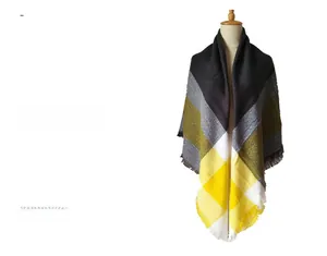 Detailed view of thick plaid scarf texture with yellow and grey tassels on a mannequin