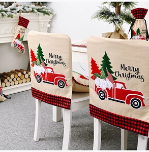 Detail of linen Christmas chair cover featuring a red truck with gnomes and plaid trim