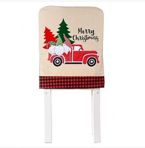 Detail of linen Christmas chair cover with red truck, gnomes, and plaid pattern