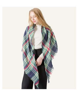 Detail shot of multi-color plaid cashmere-like shawl with classic fringe on a female model