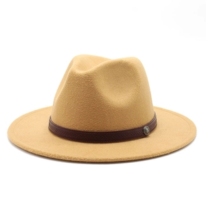 Detail view of camel wool fedora hat featuring a vintage metallic logo on leather band