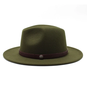 Detail of olive green fedora hat featuring wool felt texture and retro metal badge