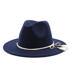 Detail of navy blue wool fedora hat featuring ivory rope band and elegant side tassels