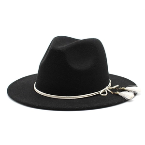 Detail of black wool fedora hat featuring white braided rope and twin tassel accents