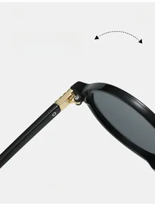 Macro detail of oval sunglasses showing durable golden metal hinges on black frame