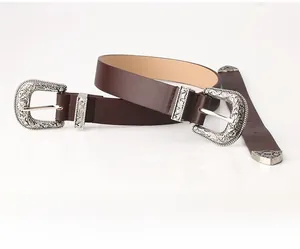 Close-up of vintage brown leather belt with ornate silver floral engraved buckles