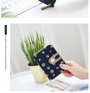 Detailed view of women's short floral wallet with zipper closure and snap button strap