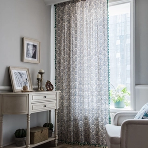 Blue porcelain pattern curtain with green tassel trim in a bright living room setting