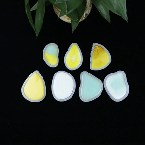 Macro detail of 7 irregular resin casting molds with colorful finished pendants