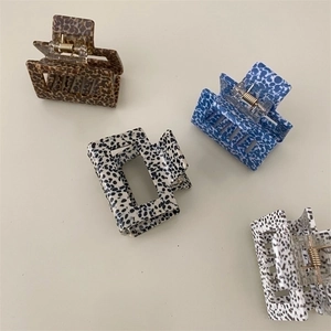 Detail of square hair claws in leopard, floral, marble, and polka dot resin patterns