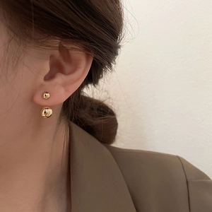 Minimalist gold double ball stud earrings worn by a model for a chic professional look