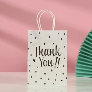 White kraft paper gift bag with black polka dots and Thank You text on pink background