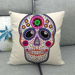 Bohemian colorful sugar skull linen pillow cover on a modern gray fabric sofa