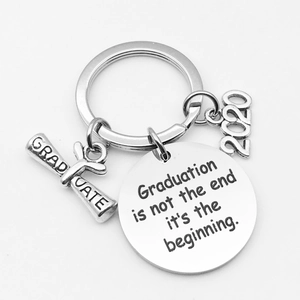 Close-up of silver graduation keychain with engraved quote and 2020 scroll charm