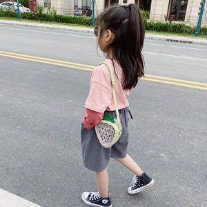 Girl wearing a shiny sequin strawberry shoulder bag in light green with leaf detail