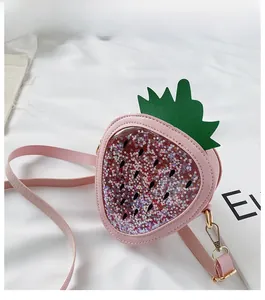 Detail of pink strawberry crossbody bag for girls featuring colorful sequins and green leaves