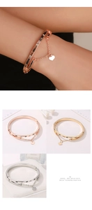 Detail of Roman numeral bangle with heart charm in rose gold, gold, and silver finishes