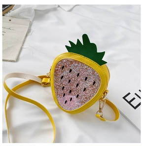 Detail view of strawberry shaped kids bag with sequins and green leaf decoration