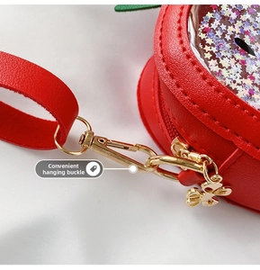 Detail of red strawberry sequin bag showing the convenient golden metal clasp and zipper
