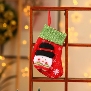 Detail of red Christmas stocking with snowman design hanging on wooden rack in warm light