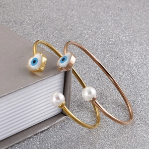 Elegant gold and rose gold Evil Eye heart bracelets with pearls on a sparkly background