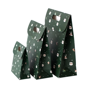 Three green Christmas gift bags with festive patterns and handles in different sizes